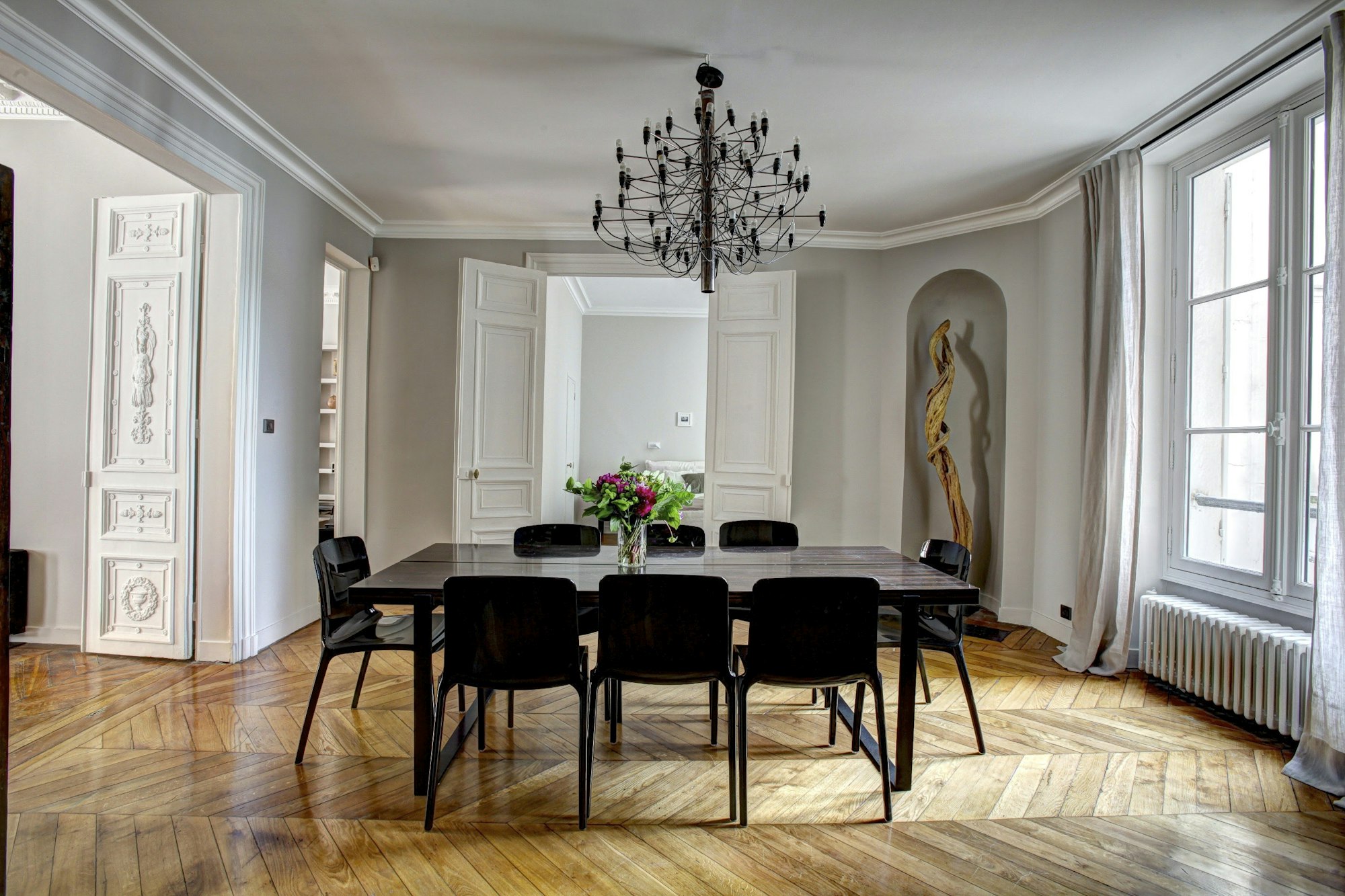 Salle à manger d’un appartement haussmannien, parquet en point de Hongrie et moulures d’origine
