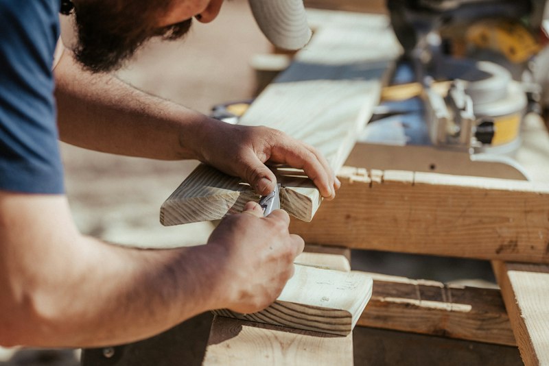 Artisan ajustant un assemblage en bois à l’atelier